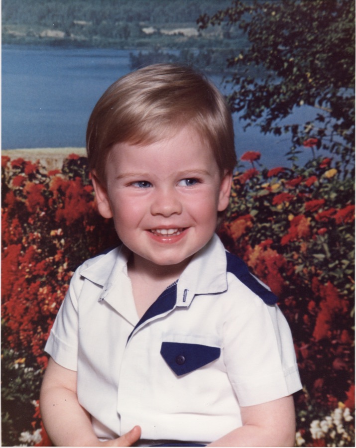 Jeff as a small child, smiling, in a white shirt