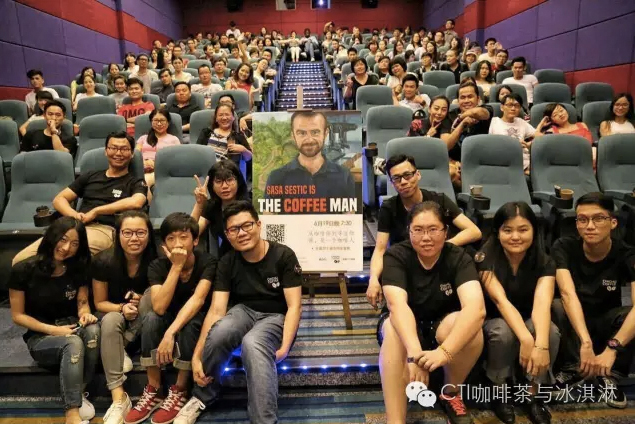A full cinema in China, the audience posing around a poster for The Coffee Man
